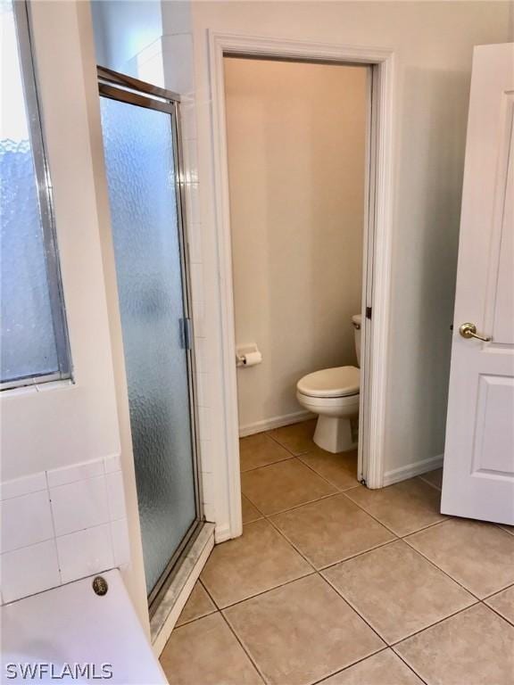 bathroom with toilet, tile patterned floors, and walk in shower