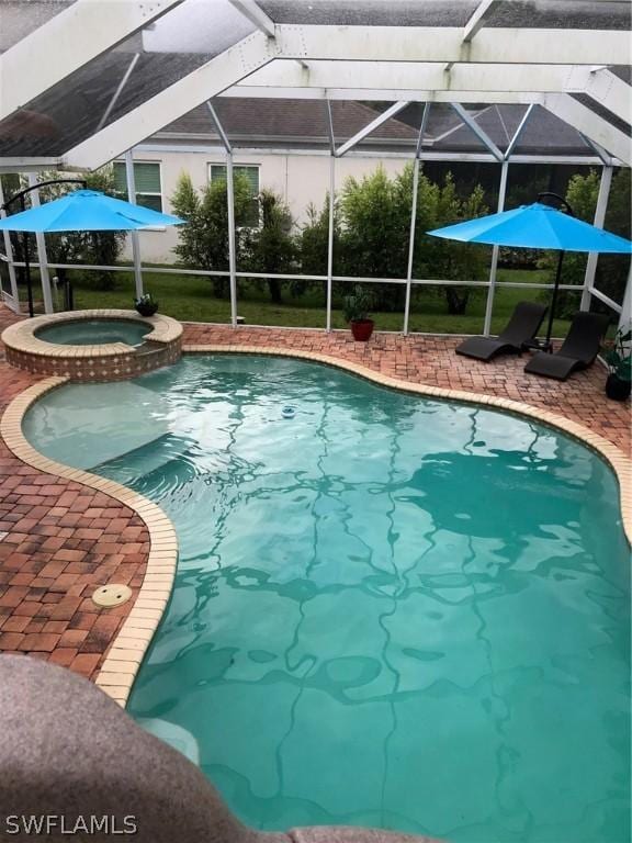 view of pool with an in ground hot tub, a patio, and a lanai