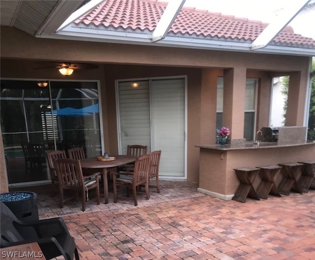 view of patio featuring a bar and ceiling fan