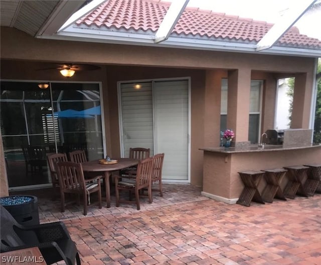 view of patio / terrace featuring ceiling fan and a bar