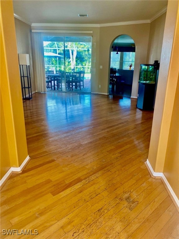 spare room with ornamental molding and light hardwood / wood-style floors