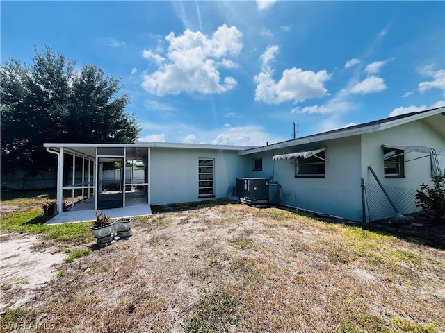 rear view of property with central AC and a sunroom