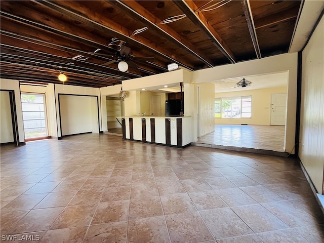 empty room featuring ceiling fan, plenty of natural light, and light tile patterned floors