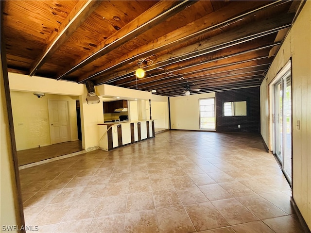 basement featuring ceiling fan, light tile patterned flooring, and brick wall