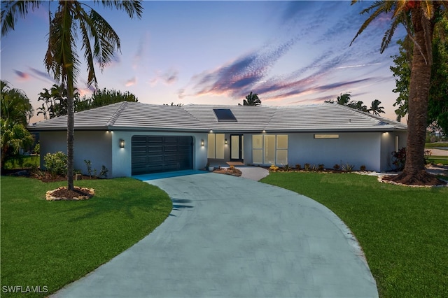 ranch-style house featuring a lawn and a garage