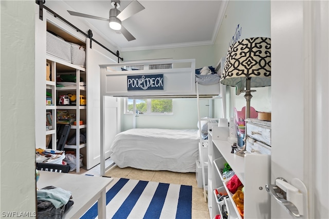 bedroom featuring a barn door, ornamental molding, ceiling fan, and light tile floors