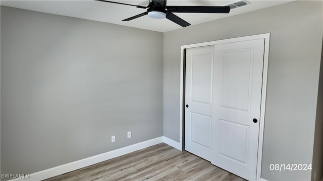 unfurnished bedroom with light hardwood / wood-style flooring, ceiling fan, and a closet