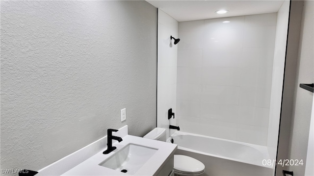 full bathroom featuring tiled shower / bath combo, vanity, and toilet