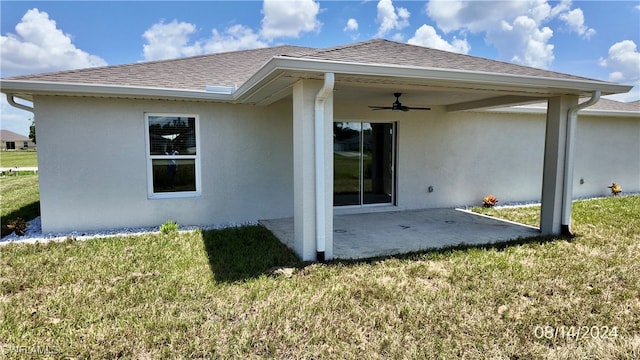 back of property featuring ceiling fan, a lawn, and a patio