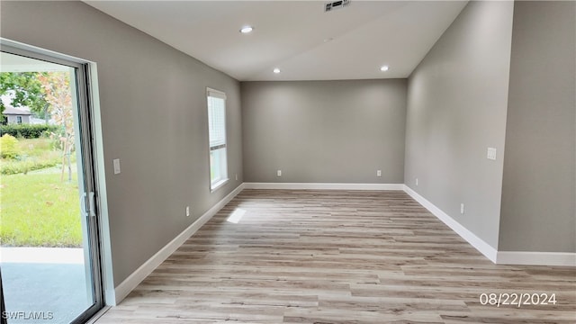 unfurnished room featuring a wealth of natural light and light wood-type flooring