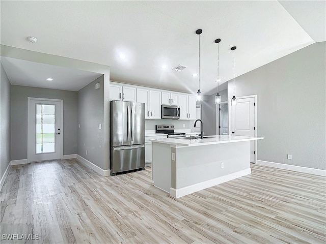 kitchen with vaulted ceiling, a center island with sink, light hardwood / wood-style flooring, stainless steel appliances, and white cabinetry