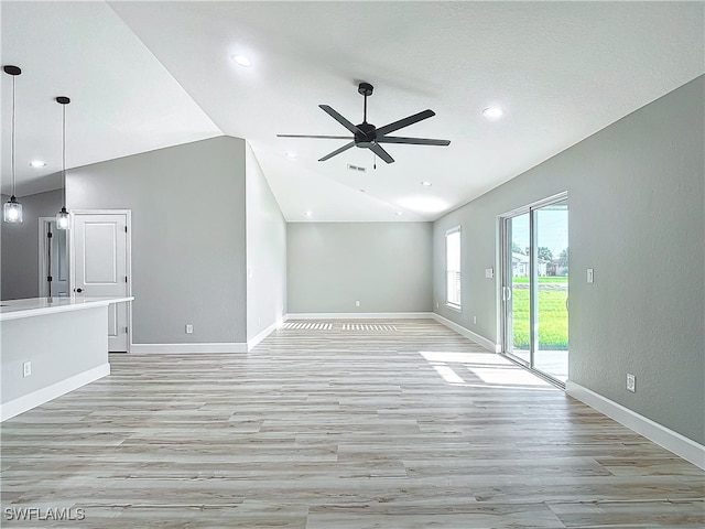 unfurnished living room featuring vaulted ceiling, ceiling fan, and light hardwood / wood-style flooring