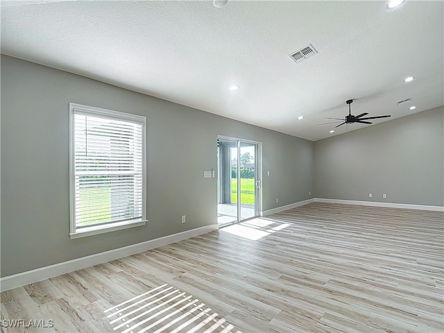 empty room with a textured ceiling, ceiling fan, and light wood-type flooring