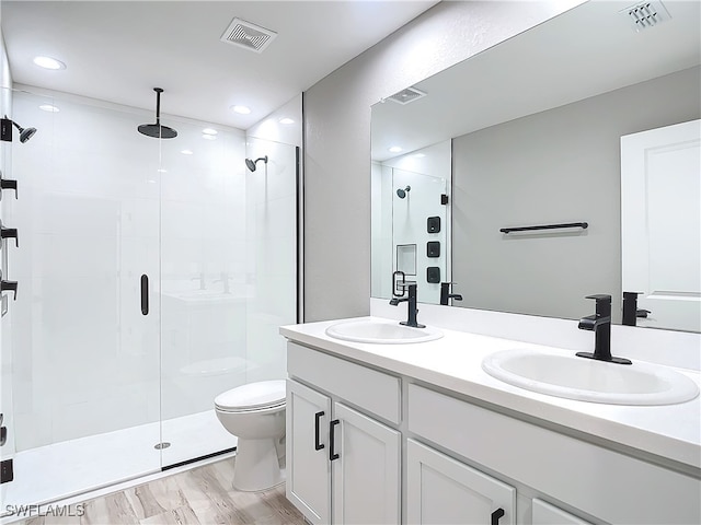 bathroom featuring vanity, toilet, an enclosed shower, and hardwood / wood-style floors