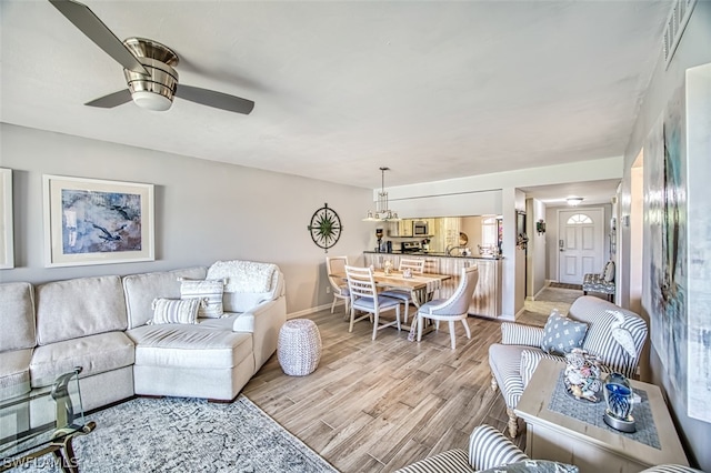 living room with ceiling fan and light wood-type flooring