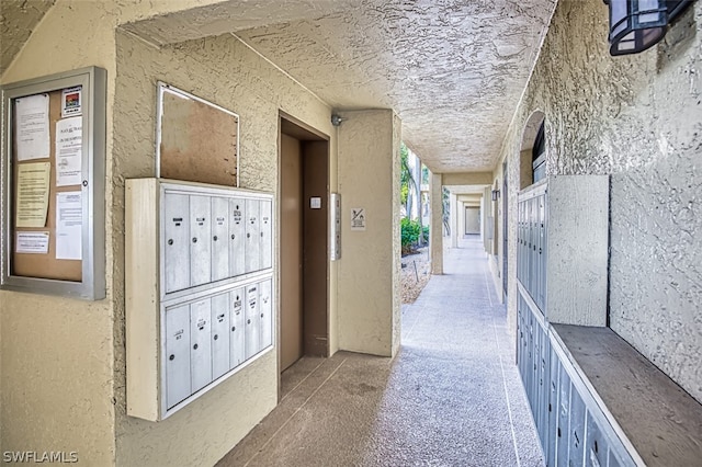 hall with elevator and a mail area