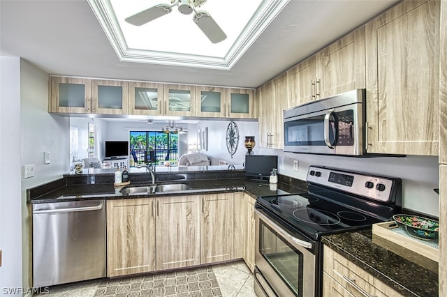 kitchen with stainless steel appliances, dark stone counters, and sink