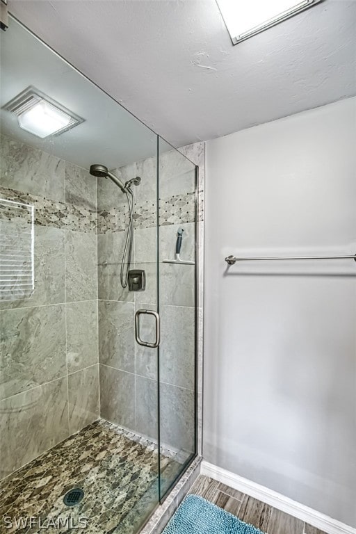 bathroom featuring hardwood / wood-style floors and a shower with door