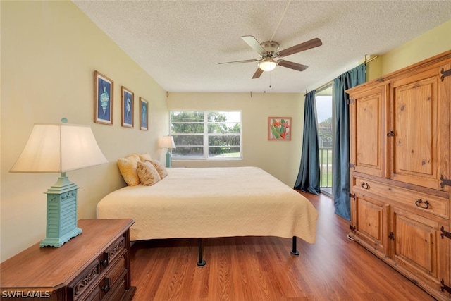 bedroom featuring ceiling fan, hardwood / wood-style floors, and a textured ceiling