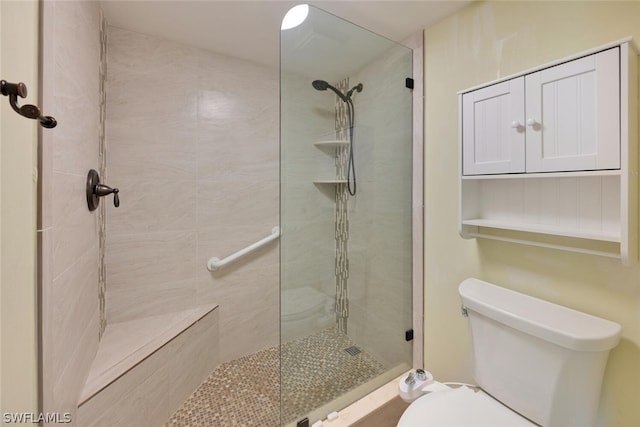 bathroom featuring toilet and tiled shower