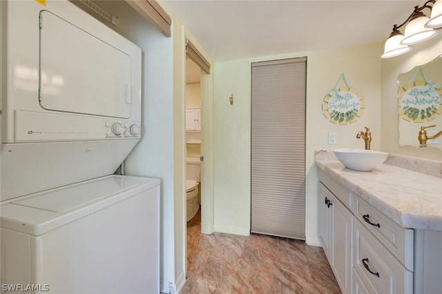 laundry room with sink and stacked washer / drying machine