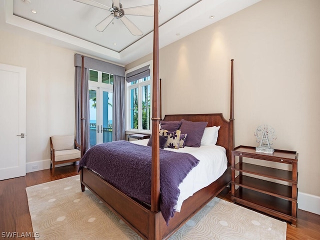 1270 Gulf Shore Blvd S, Naples, FL 34102 - bedroom featuring a tray ceiling, access to outside, baseboards, and wood finished floors