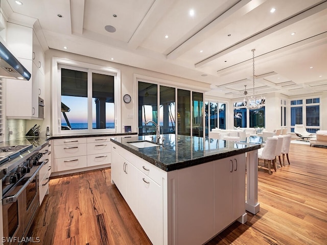 1270 Gulf Shore Blvd S, Naples, FL 34102 - kitchen featuring range with two ovens, wall chimney exhaust hood, open floor plan, a sink, and beam ceiling