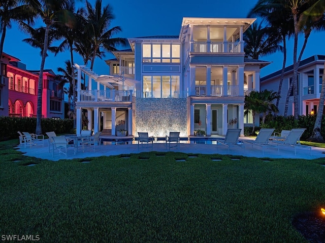1270 Gulf Shore Blvd S, Naples, FL 34102 - rear view of property featuring a balcony, stucco siding, a lawn, and a patio