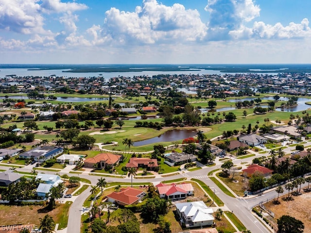 drone / aerial view with a water view, view of golf course, and a residential view