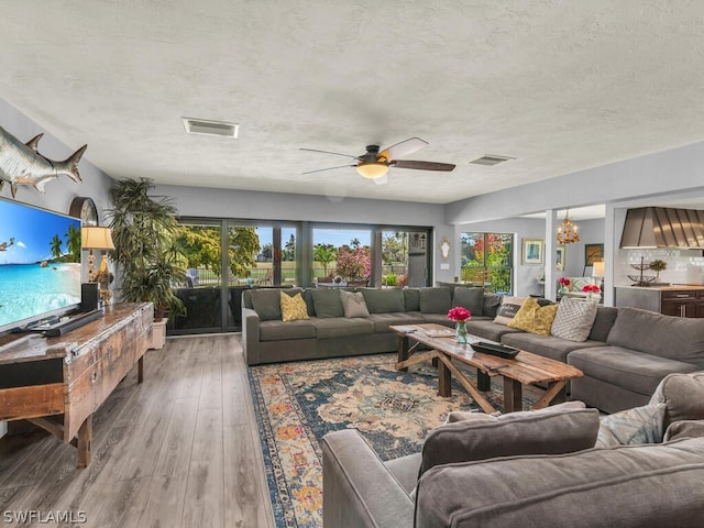 living room featuring a textured ceiling, ceiling fan, and hardwood / wood-style floors