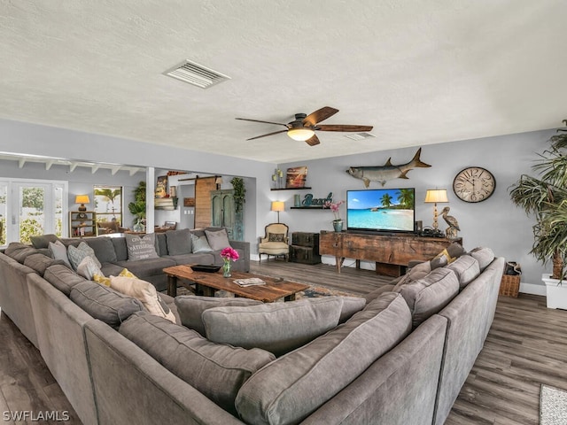 living room with a textured ceiling, dark hardwood / wood-style floors, ceiling fan, and french doors