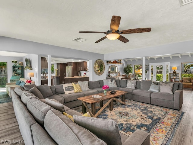 living area featuring visible vents, light wood-style floors, and ceiling fan
