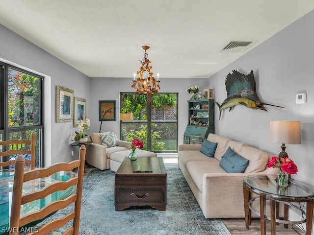 living room featuring a wealth of natural light, an inviting chandelier, and dark hardwood / wood-style floors