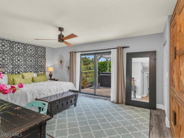 bedroom with access to outside, hardwood / wood-style flooring, and ceiling fan