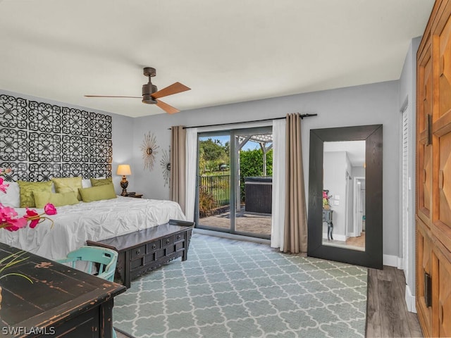 bedroom with baseboards, a ceiling fan, wood finished floors, and access to exterior