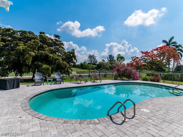 view of swimming pool featuring a fenced in pool, fence, and a patio