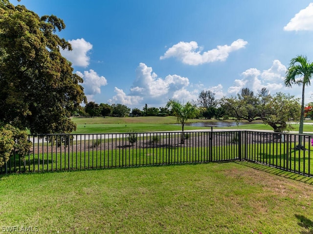 view of yard featuring fence, a water view, and golf course view
