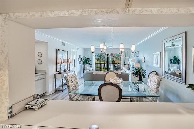 dining room featuring crown molding, ceiling fan with notable chandelier, and light hardwood / wood-style floors