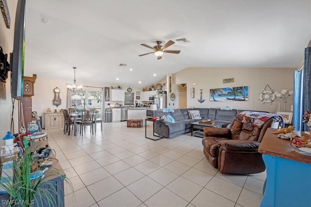 living room with ceiling fan with notable chandelier, lofted ceiling, and light tile patterned floors