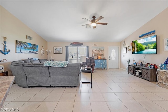 living room featuring ceiling fan, light tile patterned floors, and vaulted ceiling