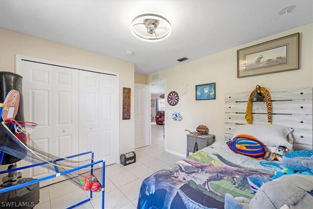 bedroom with light tile patterned floors and a closet