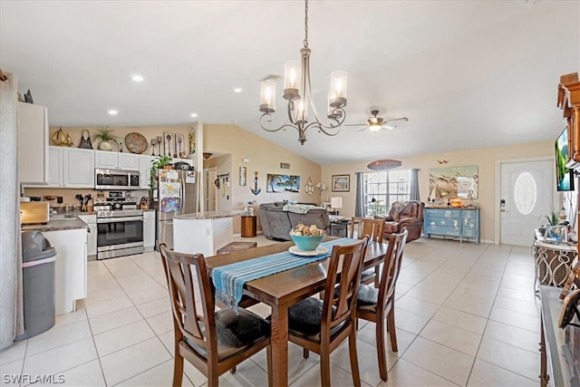 dining space with light tile patterned floors, ceiling fan with notable chandelier, and lofted ceiling