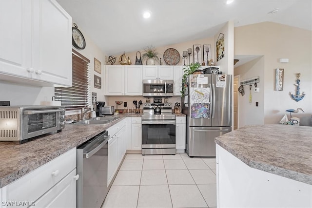 kitchen featuring white cabinets, lofted ceiling, sink, and appliances with stainless steel finishes