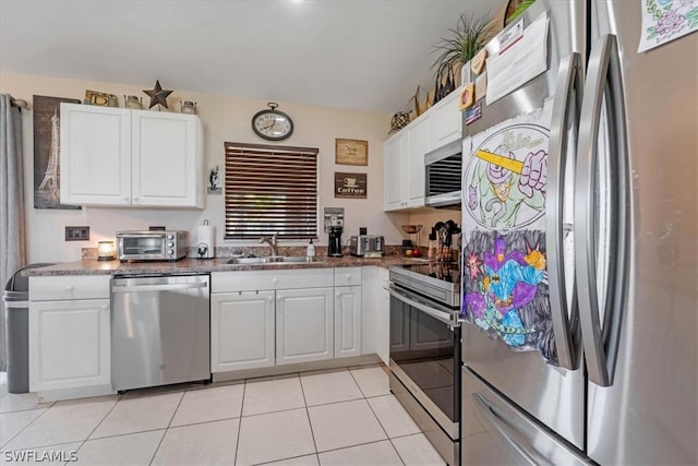 kitchen with white cabinets, sink, light tile patterned floors, and stainless steel appliances