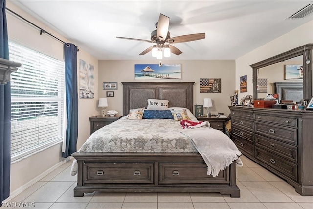 bedroom with ceiling fan, light tile patterned floors, and multiple windows