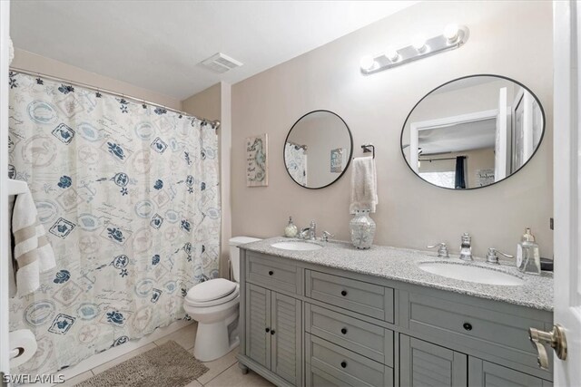 bathroom with vanity, curtained shower, tile patterned floors, and toilet