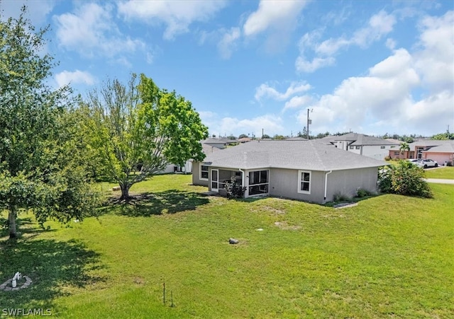 back of property with a sunroom and a lawn