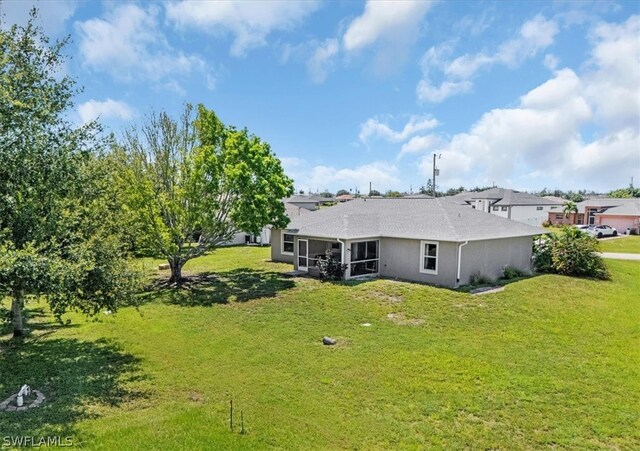 back of house with a yard and a sunroom