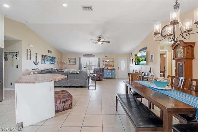 tiled dining space with vaulted ceiling and ceiling fan with notable chandelier