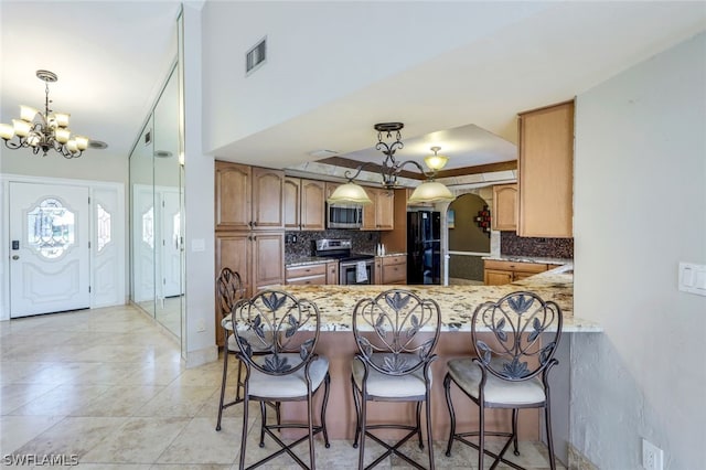 kitchen with tasteful backsplash, kitchen peninsula, hanging light fixtures, and stainless steel appliances